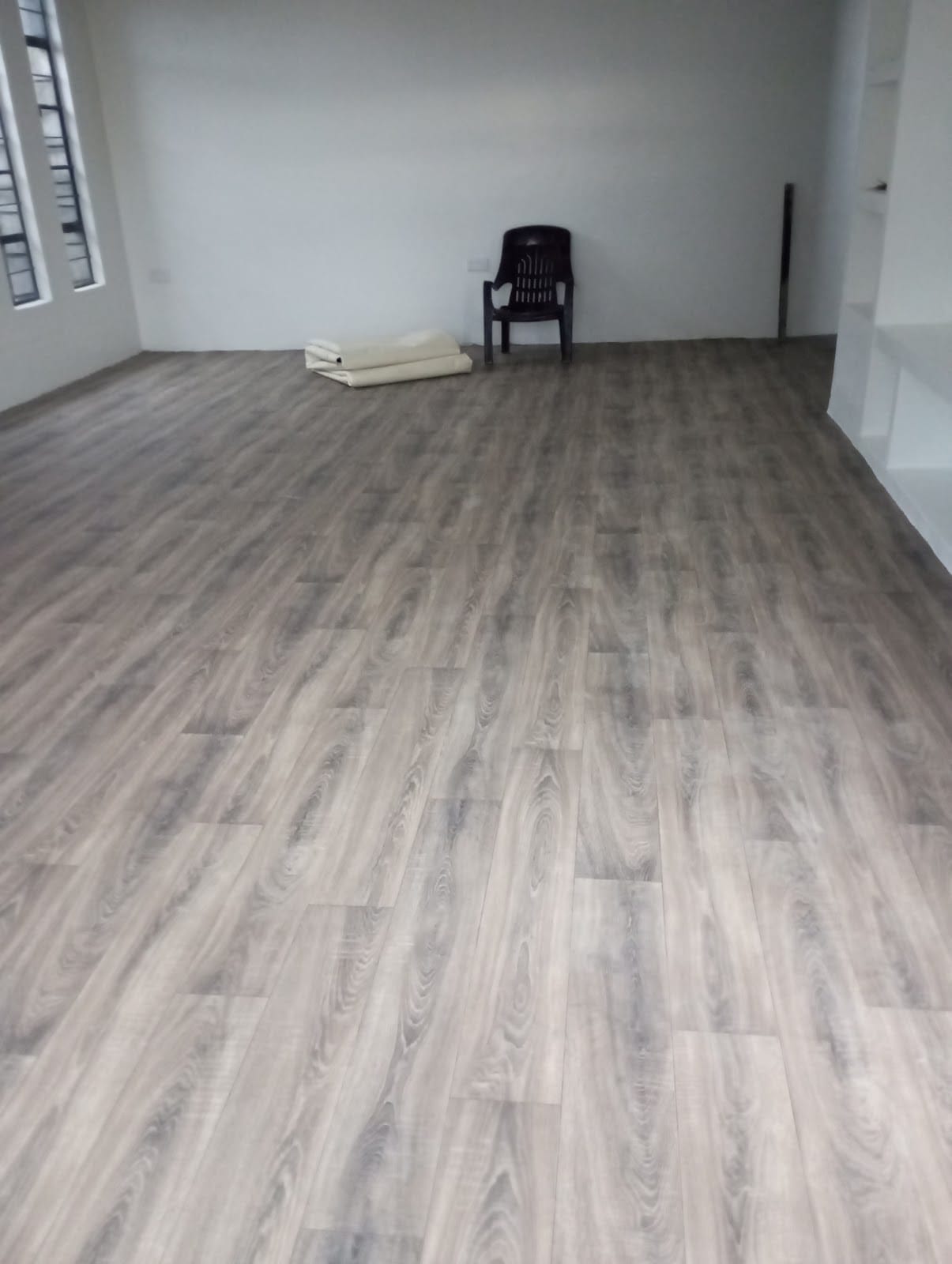 Finished grey oak SPC laminate floor in an empty room