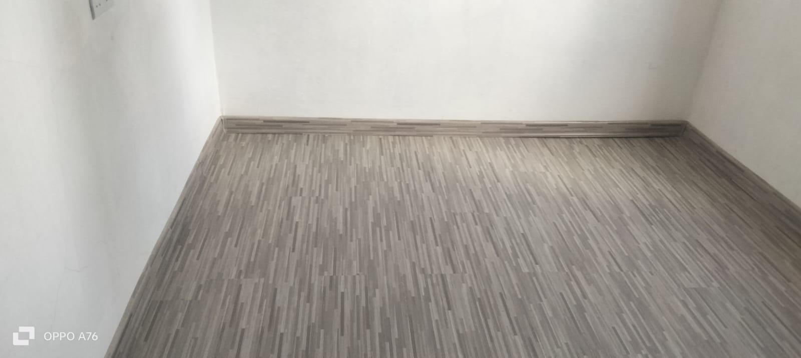 Completed grey strip SPC floor with matching skirting